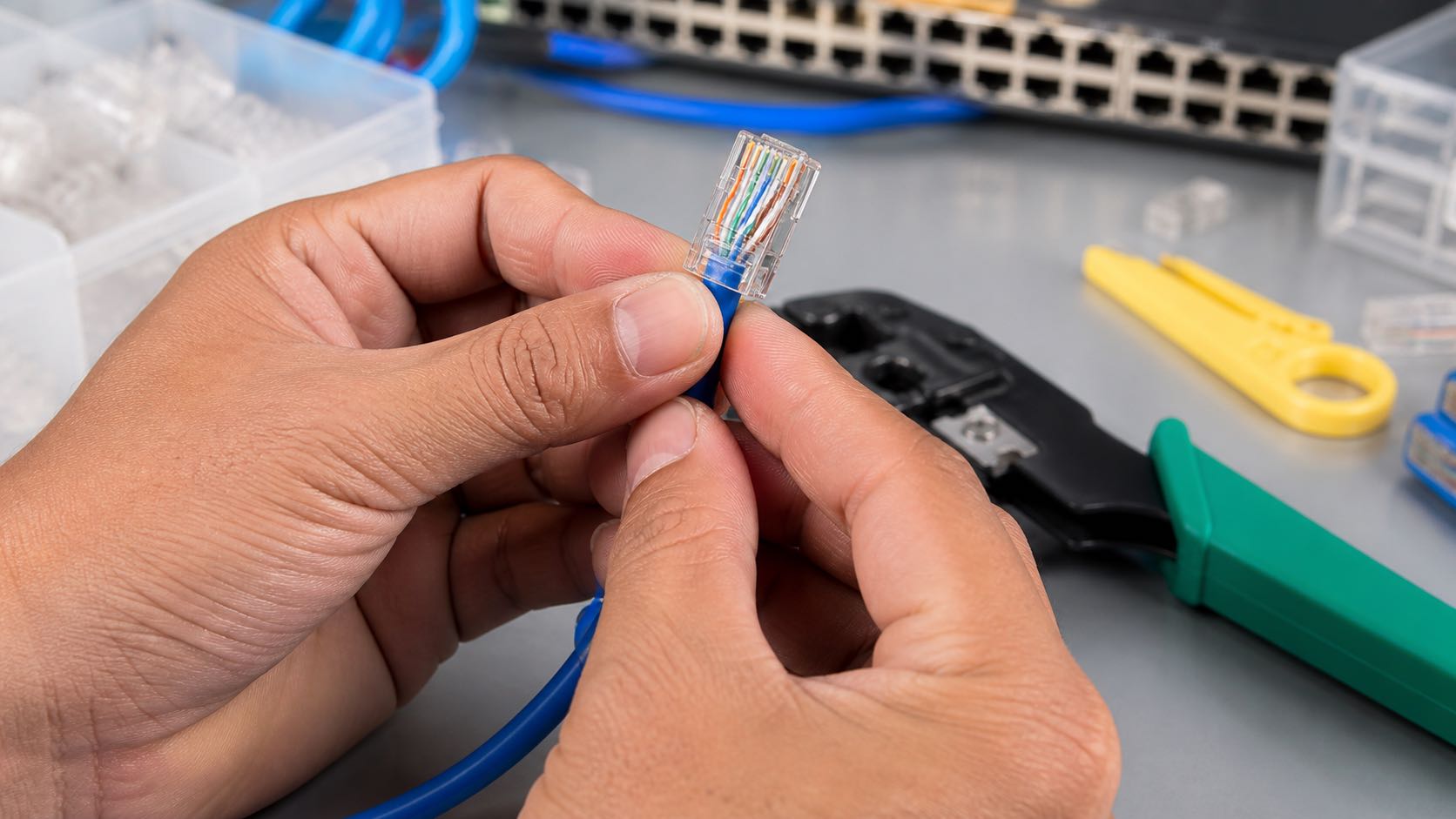Teknisi jaringan menyusun delapan konduktor kabel LAN ke konektor RJ45